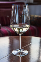Glass of white wine in a winery tasting room.