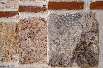 Rough cut stones and red bricks in an old wall.