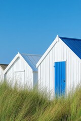 Obraz premium Vibrant beach huts are arranged in a row on the dunes of Gouville-sur-Mer, a town in Lower Normandy, France