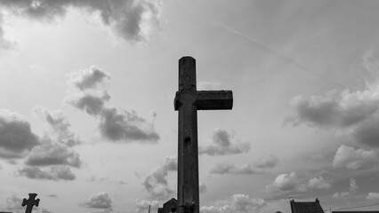 Fototapeta premium Broken stone cross in a historic war cemetery in black and white