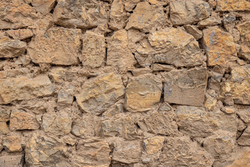 Patterns in a rough stone and mud wall.