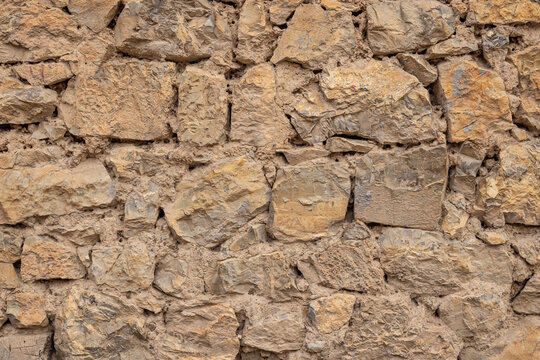 Patterns in a rough stone and mud wall.