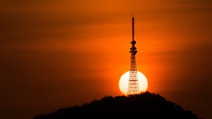 Obraz premium silhouette of radio tower at sunset with glowing signals