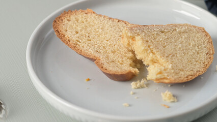 Folar slice with egg and feather on a white plate