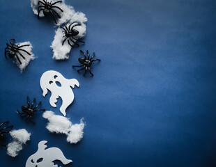 ghosts and spiders on webs on a blue background with space for text, Halloween theme