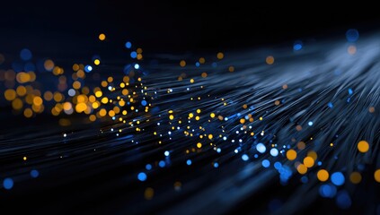 Abstract network of fiber optic cables.  Golden and blue lights disperse along dark lines