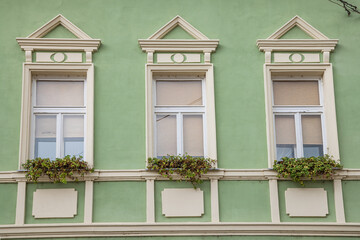 Windows on an old green building in Novi Sad.