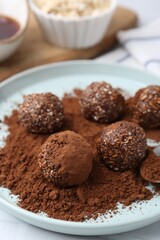 Delicious homemade candies with cocoa powder on table, closeup