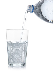Pouring refreshing soda water from bottle into glass on white background