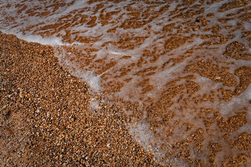 Wave Receding on Close-Up Pebble Beach Shoreline