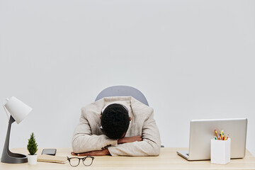 Businesswoman overwhelmed exhausted stressed in office sitting at desk with head down, workplace...