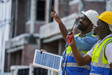 Two construction site managers collaborating on a building inspection. A supervisor points out an issue while his colleague takes notes, ensuring quality control and project progress.
