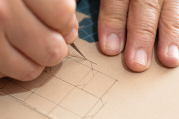 Person using a scalpel to cut the template of a miniature cardboard box. Planning and measurements...