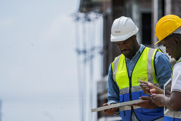 An experienced engineer teaches an apprentice about solar panel installation on a construction...