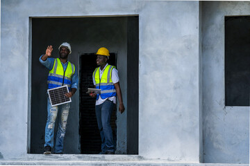 Black professionals collaborating on a renewable energy project. A senior engineer and his partner...