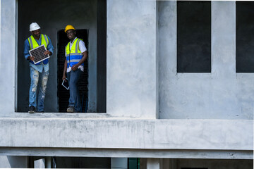 Black professionals collaborating on a renewable energy project. A senior engineer and his partner...