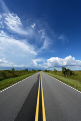 Fototapeta premium Bright summer cloudscape over Main Park Road in Everglades National Park, Florida.