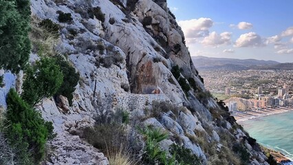 Experience a Stunning Coastal View from Rocky Cliffs with a Scenic City Background Nearby