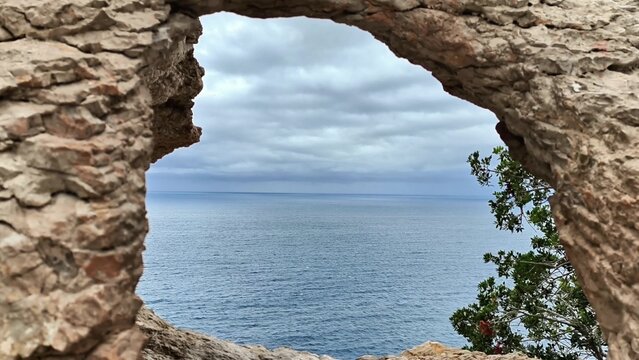 Fototapeta A breathtaking scenic view seen through a stone arch, beautifully overlooking a calm ocean