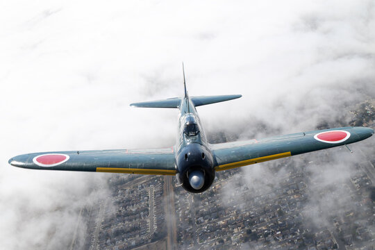 Frontal view of a A6M "Zero" (WWII Japanese fighter plane) flying over clouds in South California