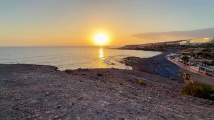 Experience the Stunning Sunset Over Ocean Shoreline Featuring a Black Sand Beach