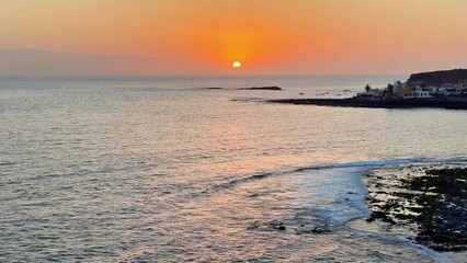 Experience the breathtaking sunset over tranquil coastal waters, a sight that captivates all