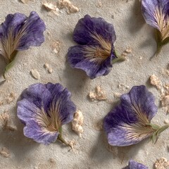 Delicate, muted lavender flowers arranged on a light beige textured surface