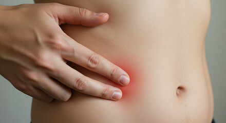 Fototapeta premium Abdominal Pain A Close-Up of a Hand Touching a Person's Stomach, Highlighted by Redness