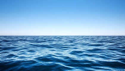Obraz premium The illustration shows a wide expanse of deep blue ocean water with small waves, set against a clear, bright blue sky with a few wispy clouds on the horizon.