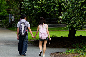 Couple Walking Hand-in-Hand Through Lush City Park During Summer
