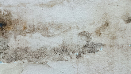 Weathered painted beige wall with dirt and aged imperfections. Grunge detail background with cracked layers and rustic patina, suitable for texture overlays or vintage urban design projects.