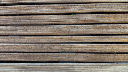 Detail view of aged bamboo wall with horizontal grooves and natural wear, great for sustainable...