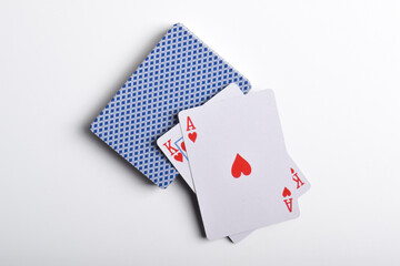 A deck of playing cards with a pair of aces on top isolated on white background