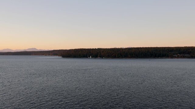 Passing a Lighthouse on the West Coast of British Columbia, Canada near sunset, twilight, or dusk from a Cruise Ship or Boat