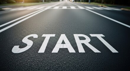 Close-up of asphalt road with "START" marking and crosswalk ahead, sunny day