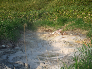 Volcanic mud pots in Iturup green landscape, Kuril islands