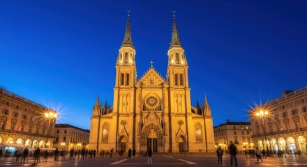 Fototapeta premium Illuminated cathedral at twilight with blurred people