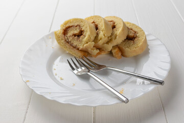 Sliced Swiss Roll Cake on White Plate with Forks