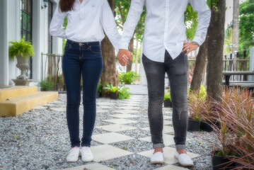Fototapeta premium Close up of married couple holding hand each other in park during sunset. Attractive romantic groom and bride celebrating their love and Valentine's day