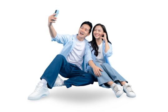 A cheerful couple taking a selfie and enjoy the moment. They are sitting and smiling, with their phone held up high on PNG background