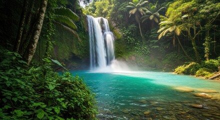 Obraz premium Turquoise pool beneath a cascading waterfall in a lush, green tropical forest