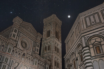 Florence Cathedral Santa Maria del Fiore at night and starry sky by the river.