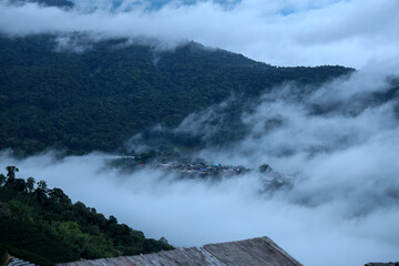 Misty Mountain Village Surrounded by Dense Fog and Lush Greenery in Serene Nature Landscape