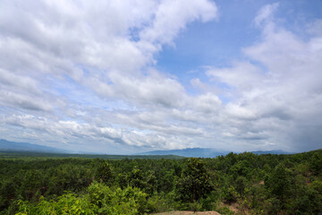 Obraz premium Lush Green Landscape Under Cloudy Sky with Vast Horizon and Scenic Mountain View
