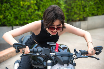 Young brunette attractive hipster biker woman riding on motorcycle
