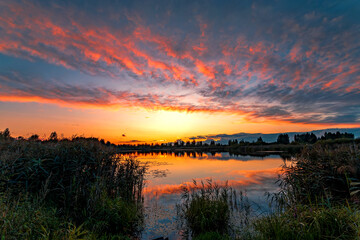 Summer sunset with beautiful sky over the lake.