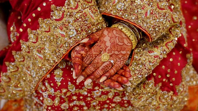 Bride opens her hands while posing for photo shot, dressed in red traditional Indian clothes, Elements of Asian wedding. 