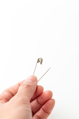 安全ピンを持つ手元　白バック