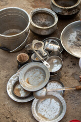 Used Metal Plates, Pots and Utensils Placed on Ground after Meal in Rural Outdoor Setting Depicting Traditional Lifestyle