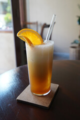 Close up glass of citrus orange cocktail on wooden table